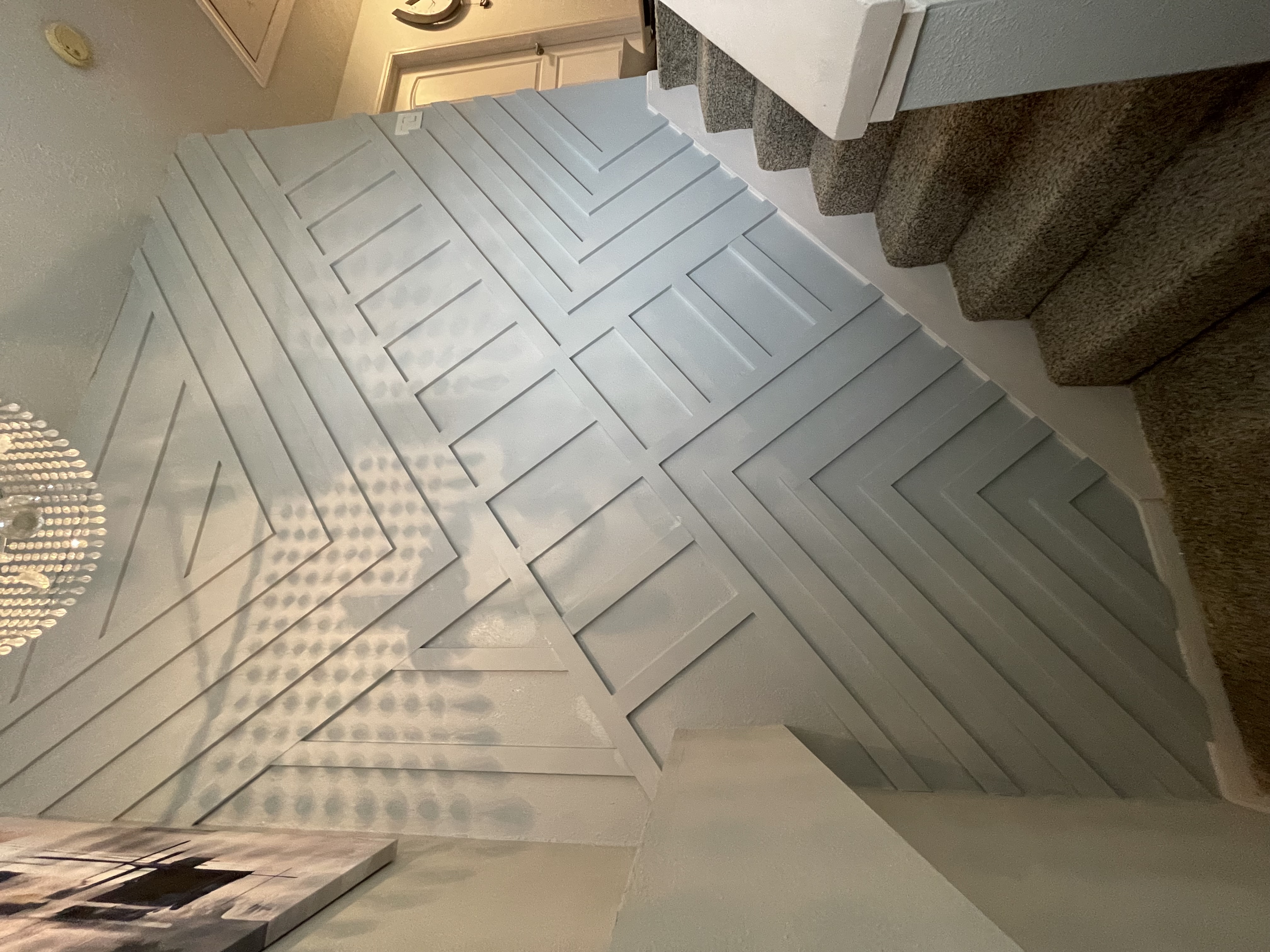 Light blue geometric accent wall by stairway
